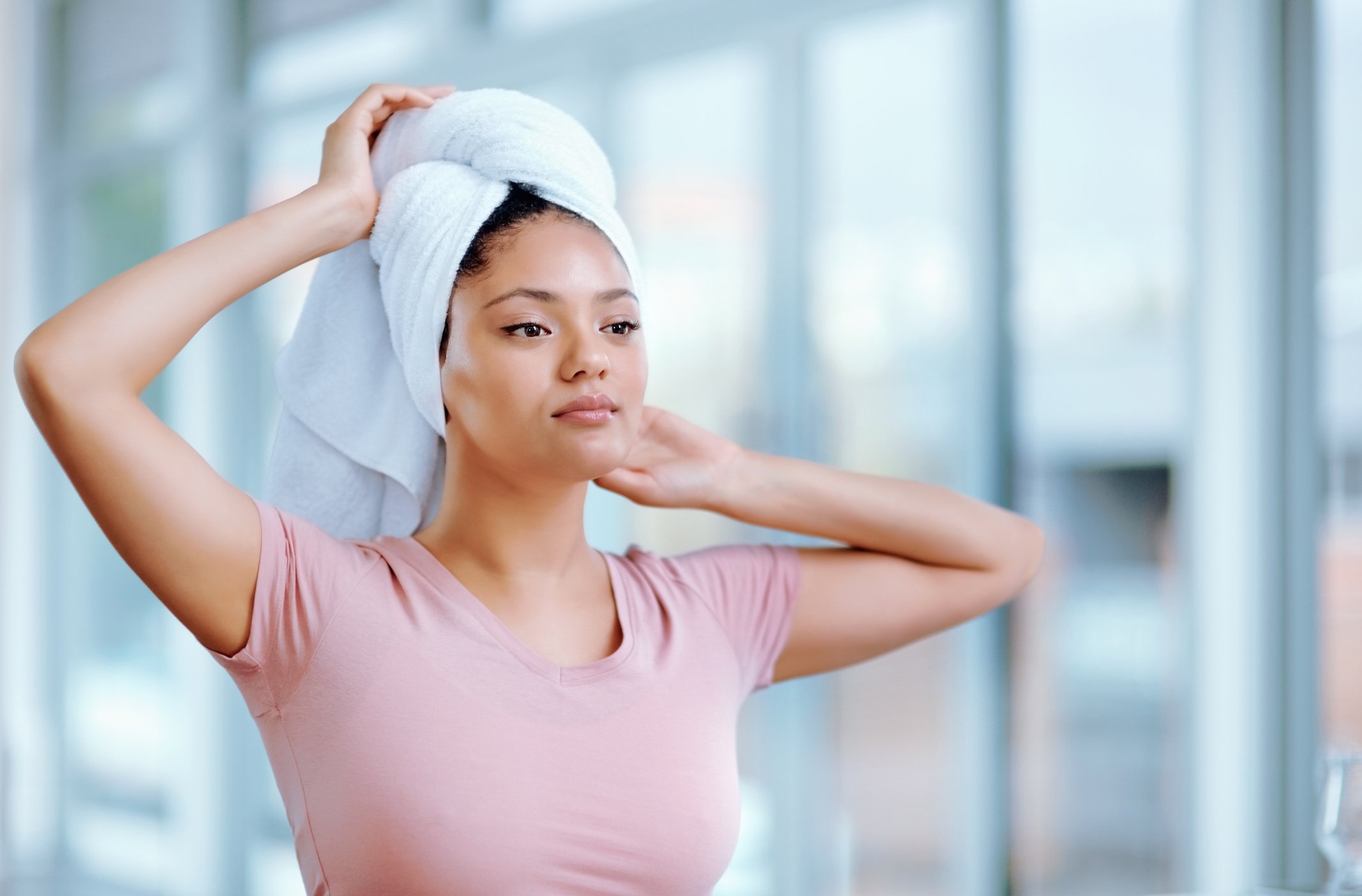Young woman puts her hair in a towel to leave for drying
