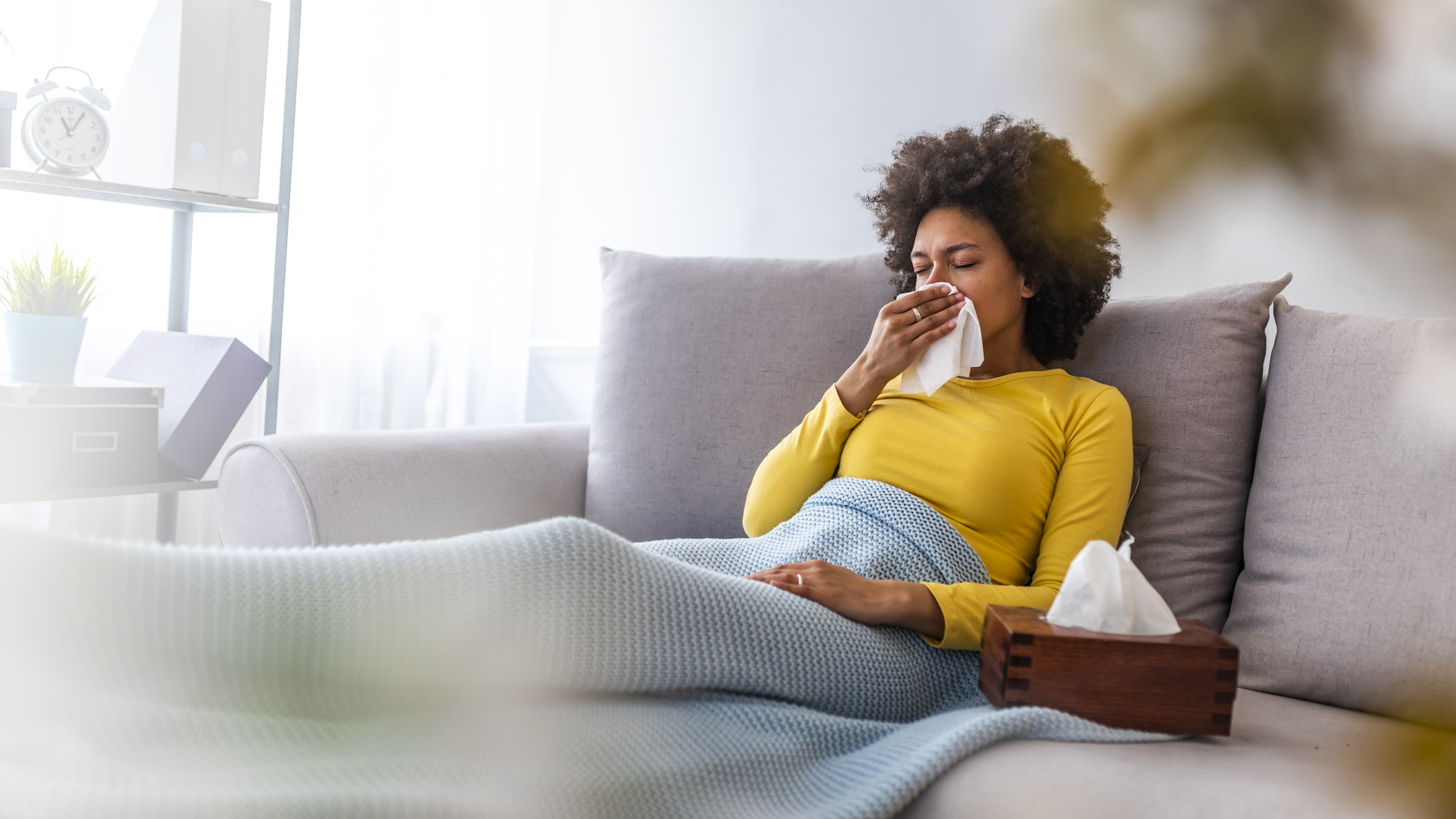 Woman suffering from allergies rests on the couch